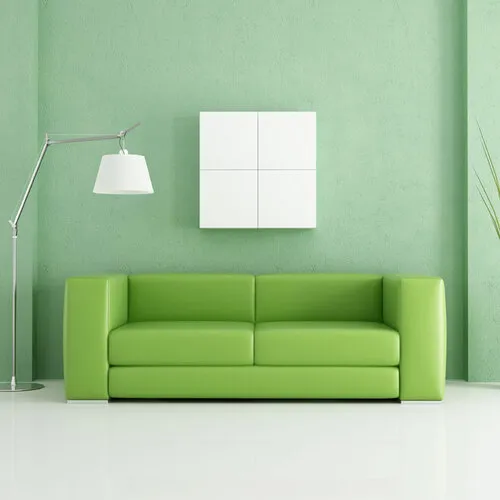 Modern green living room with sofa, white wall unit, and lamp